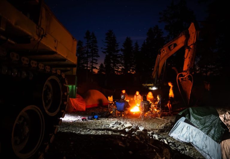 Members of the Raincoast Flying Squad by a camp fire at the forestry road construction blockade north of Port Renfrew, B.C.