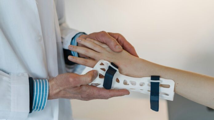 Doctor puts a wrist guard on a patient.